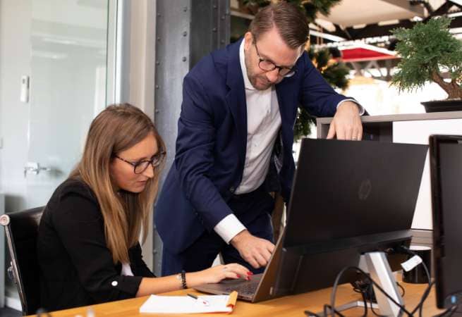 collaborateur aidant sa collegue sur un ordinateur